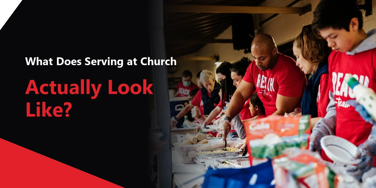 Action Church volunteers in red Reach Team shirts serving food together.