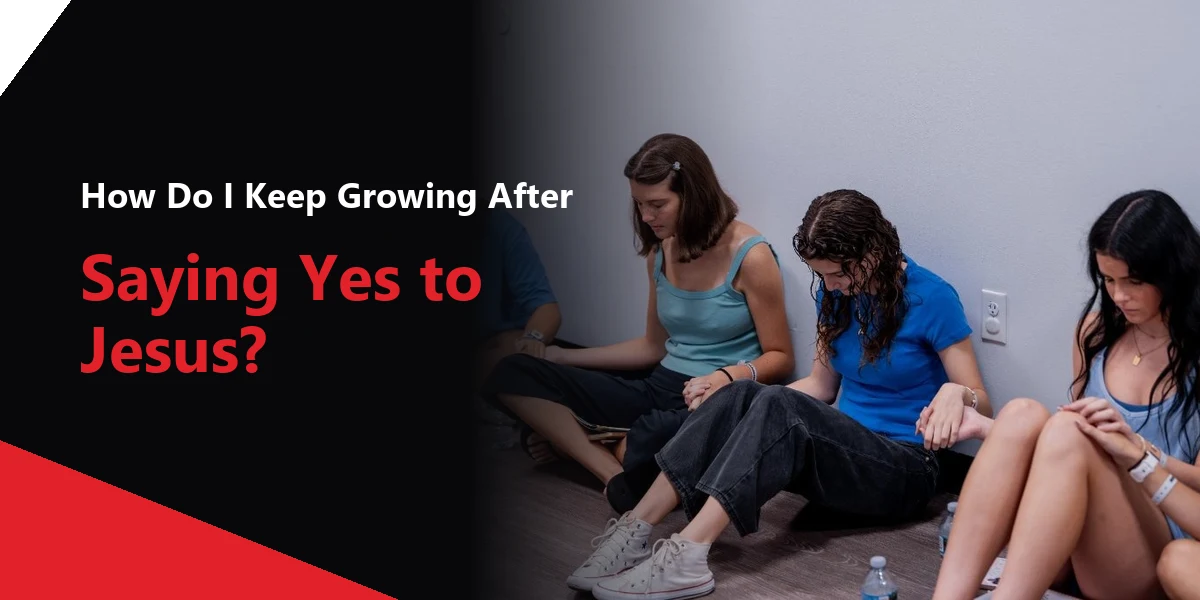 A group of young women sitting together on the floor in prayer.